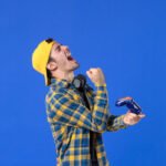 front-view-male-gamer-with-gamepad-playing-video-game-blue-wall (1)