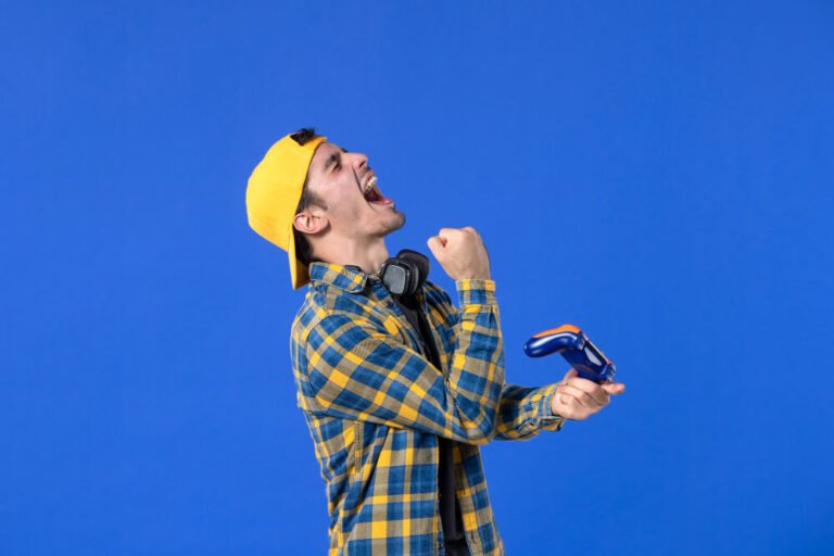 front-view-male-gamer-with-gamepad-playing-video-game-blue-wall (1)